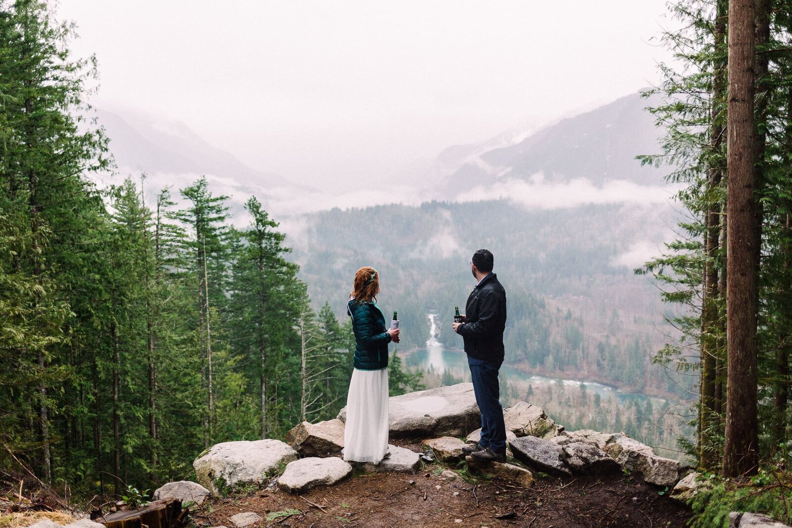 couple looking at view of distant waterfall in wedding attire