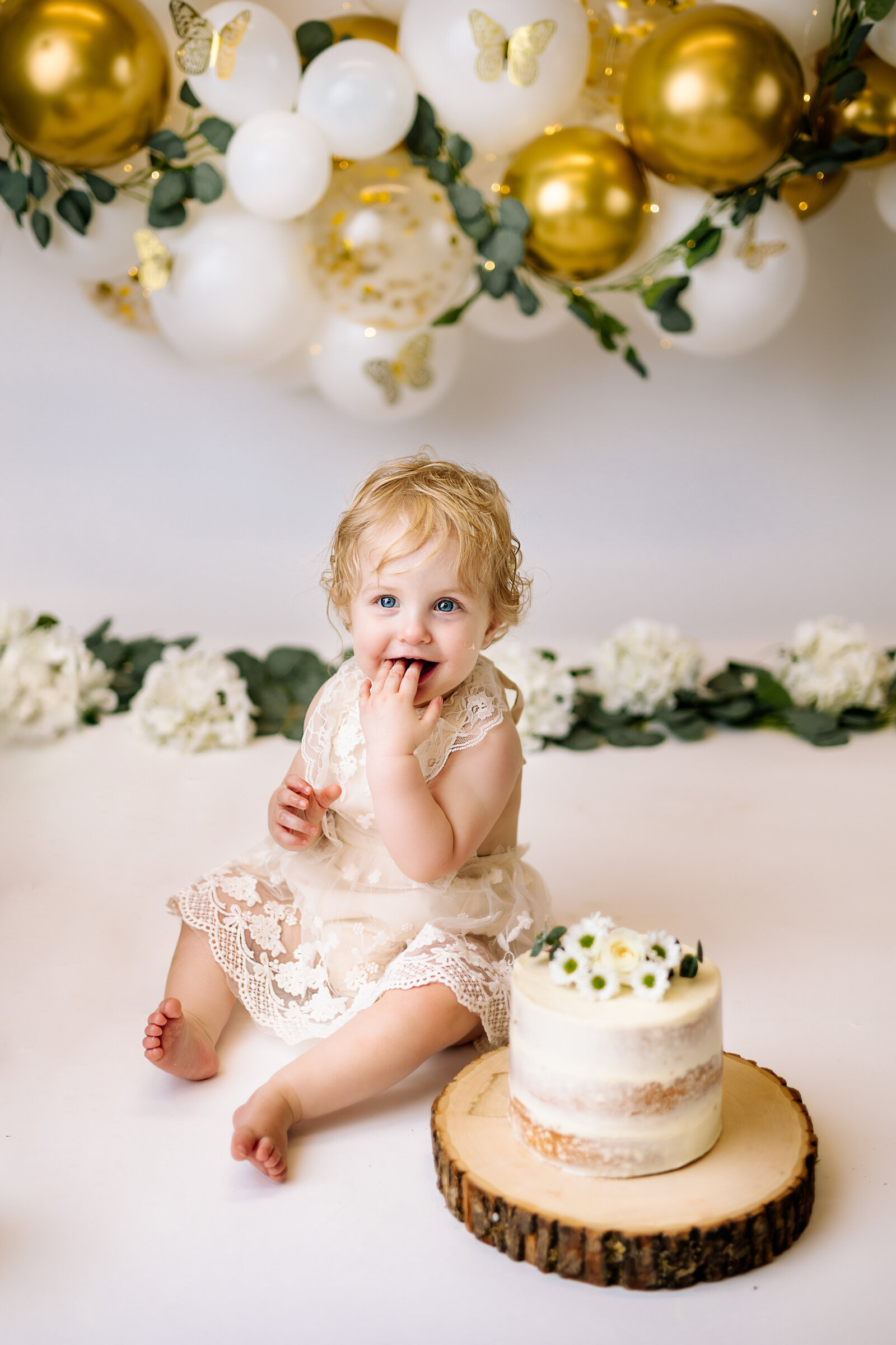 Sweet baby girl enjoys the first bite of her  smash cake
