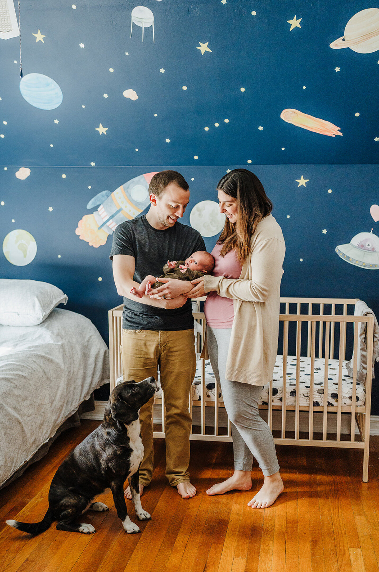 parents with baby and dog in space themed nursery