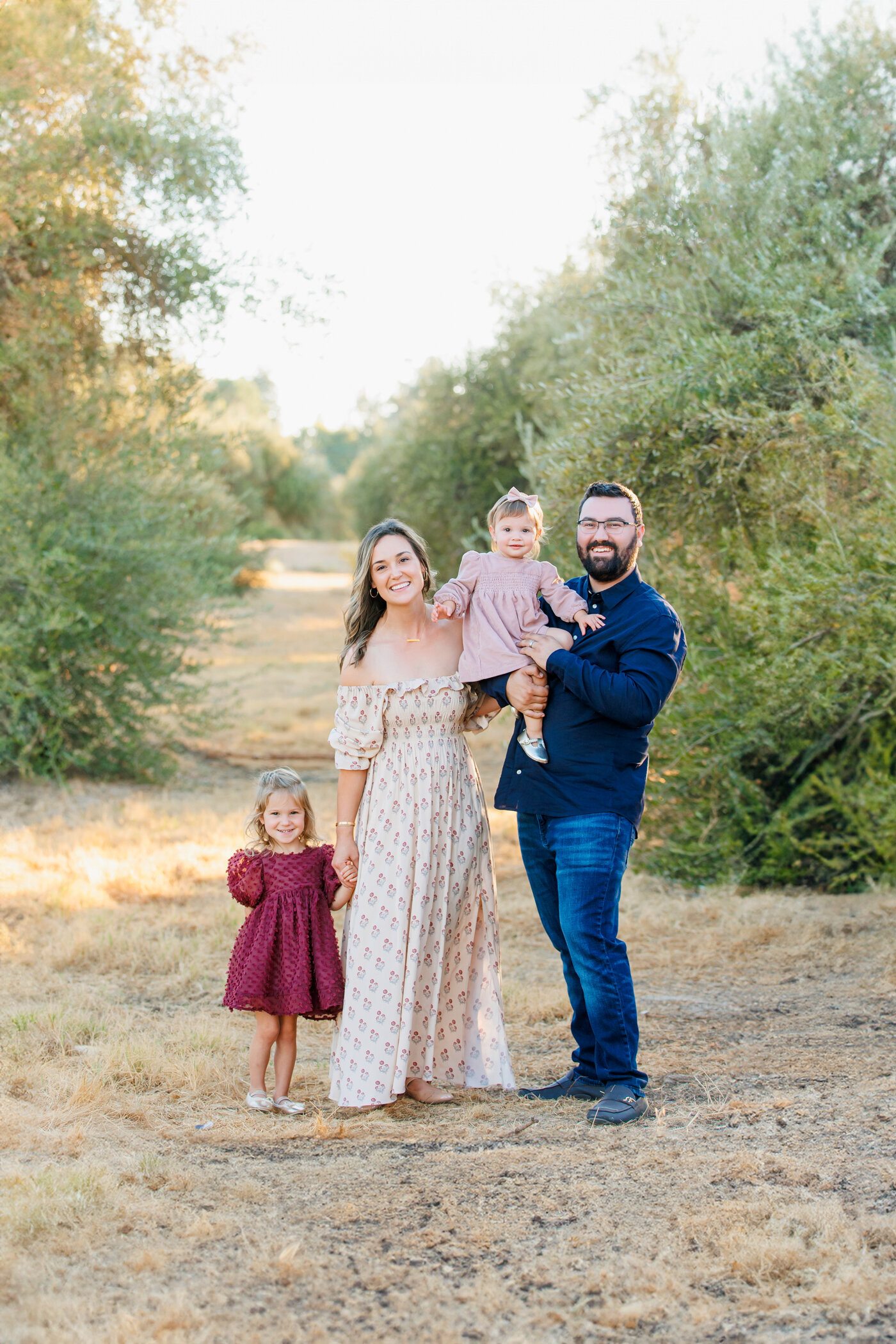 Family of four photographed in a field of oliive trees. light bright airy, fresno, clovis, photo, one good shot