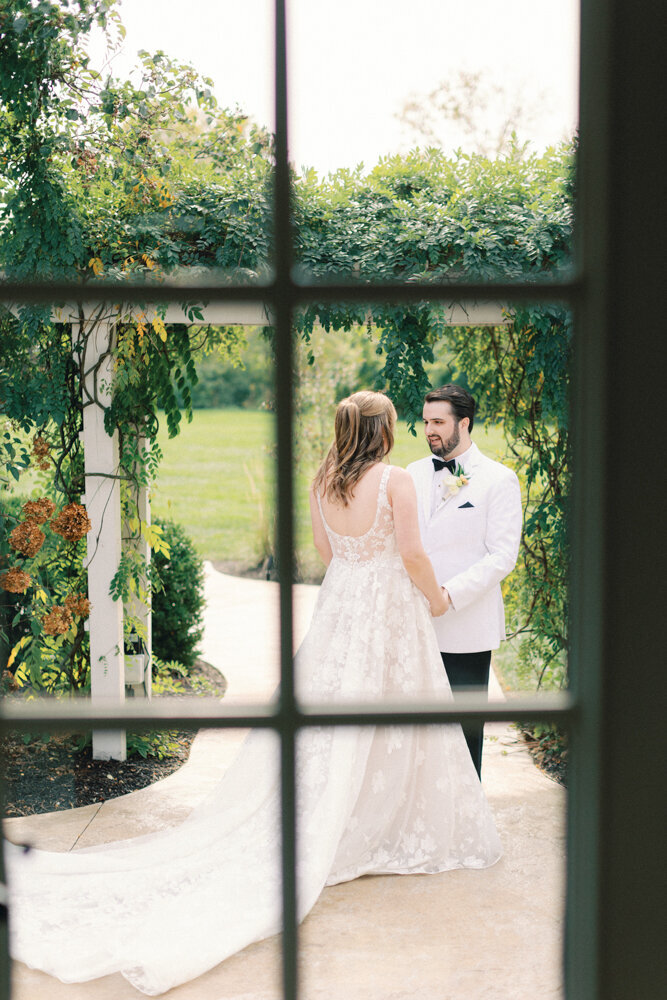 bride and groom first look through window