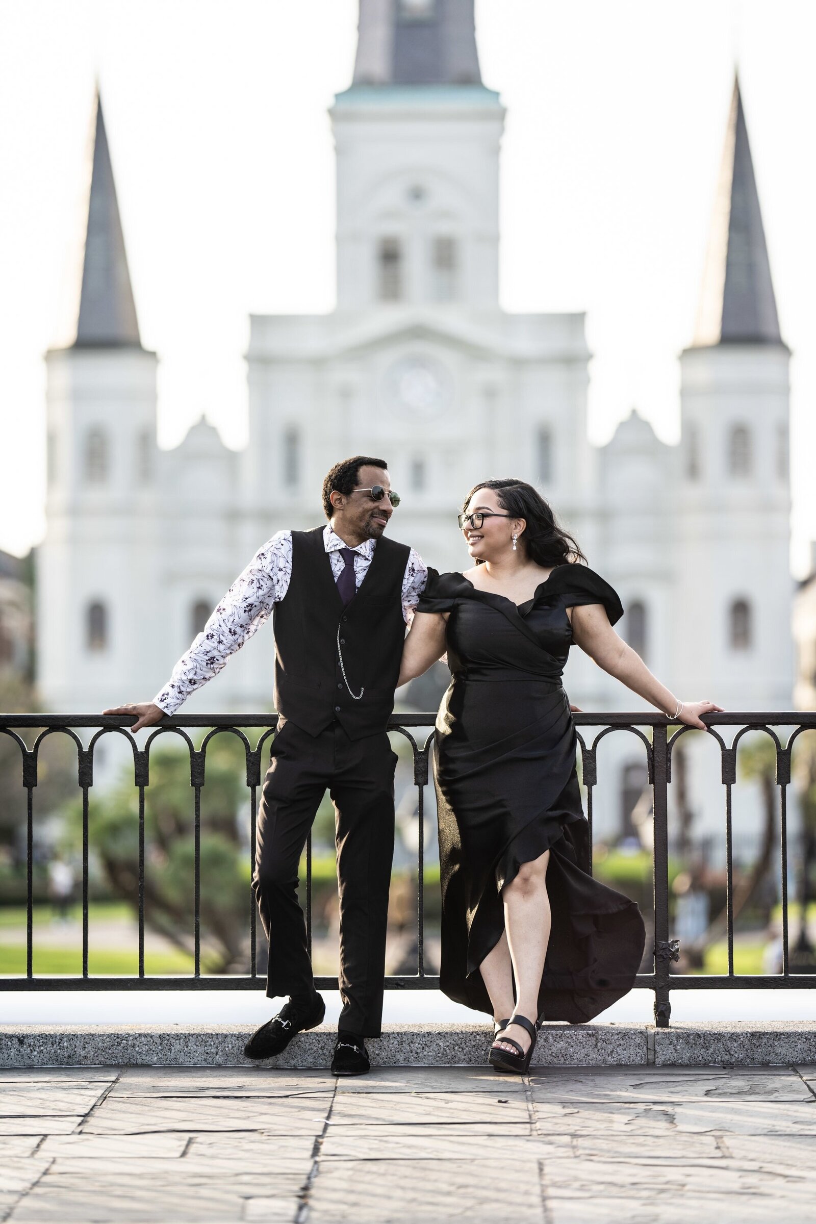Couple leaning against railing with St. Louis Cathedral in the background
