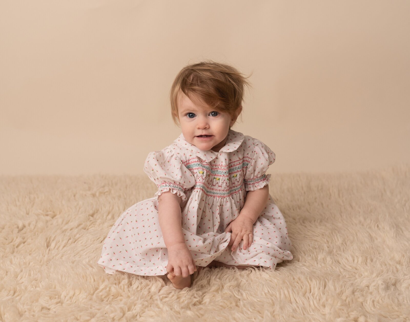 little girl wearing a vintage smocked dress in a studio for pictures