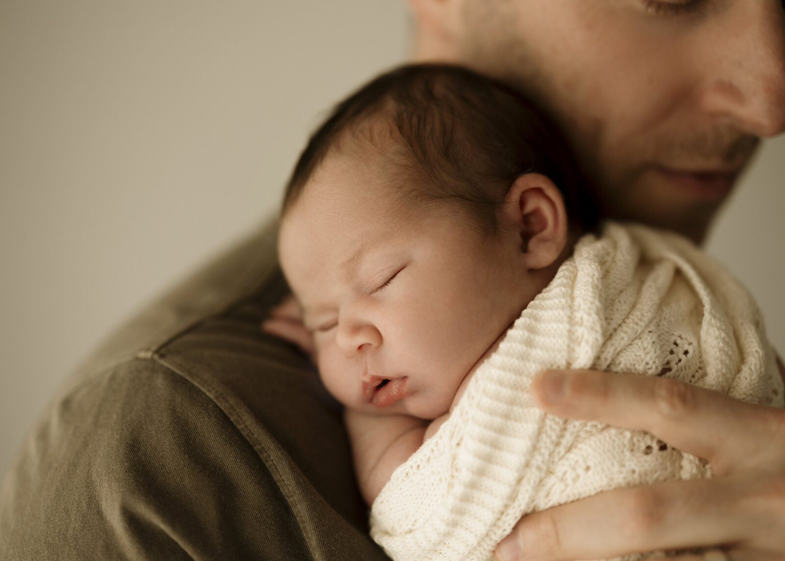 Mum, dad, and baby in a Perth studio newborn photoshoot, capturing the joy of welcoming a new addition to the family.