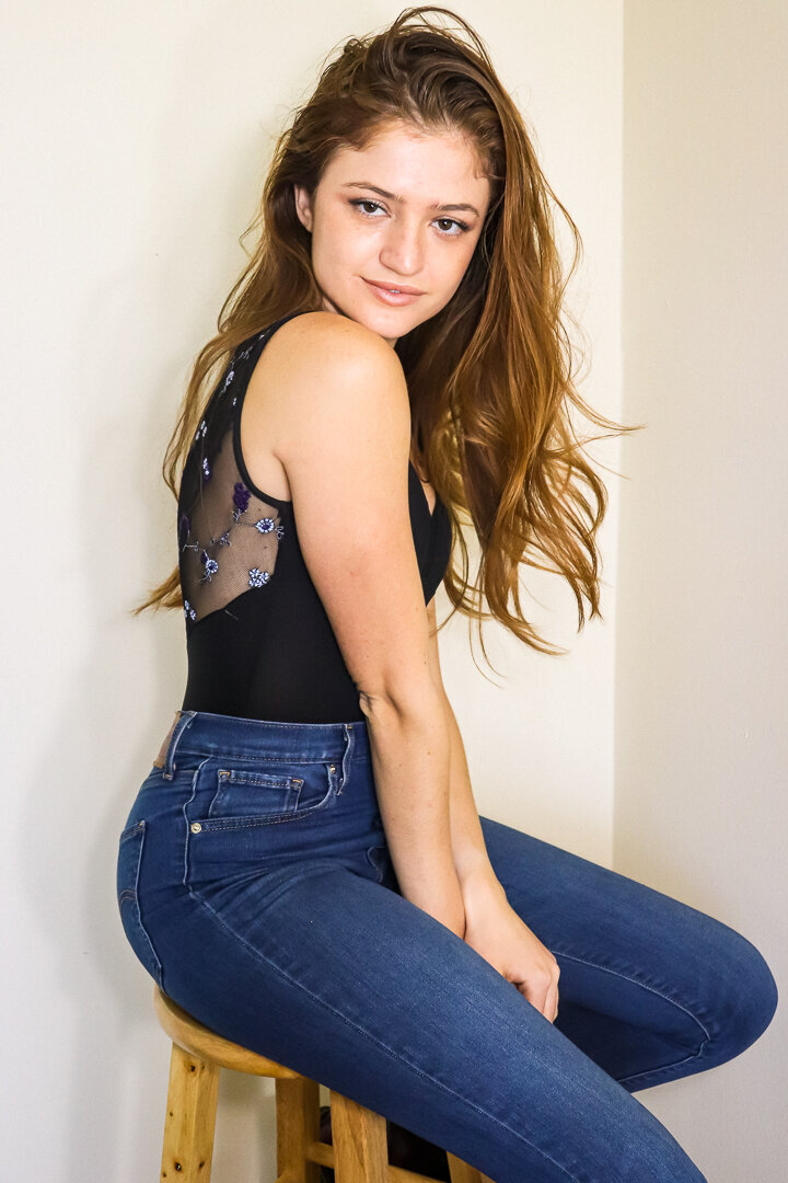 woman sitting on stool looking at the camera