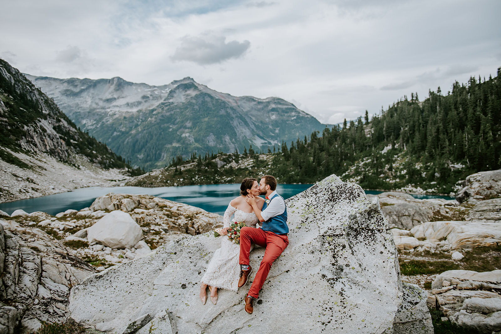 Couple happily running down the dock, in the rain after their beautiful Chatterbox falls elopement with Coastal Weddings and events.