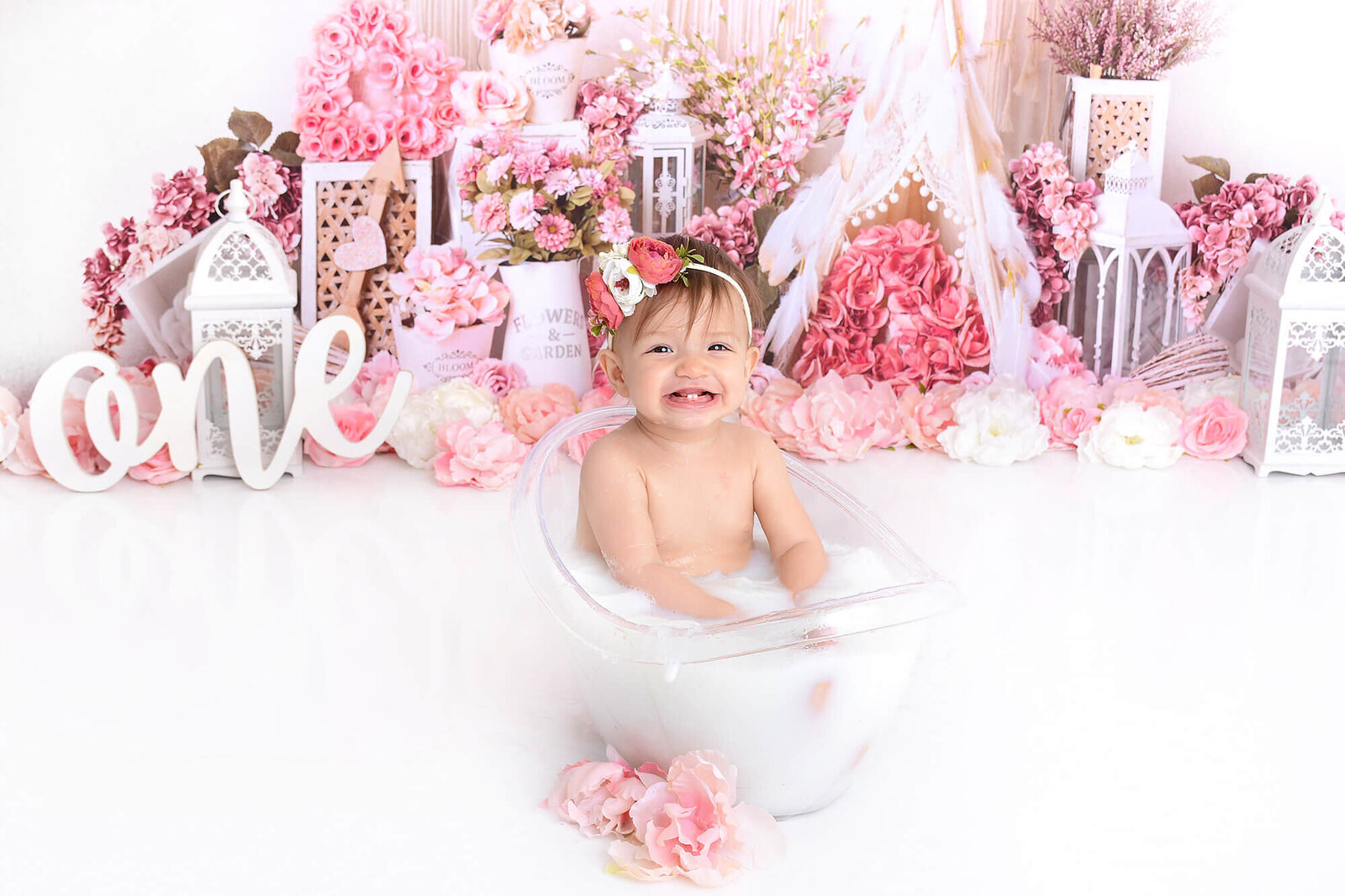 baby girl smiles in a milk bath in houston studio