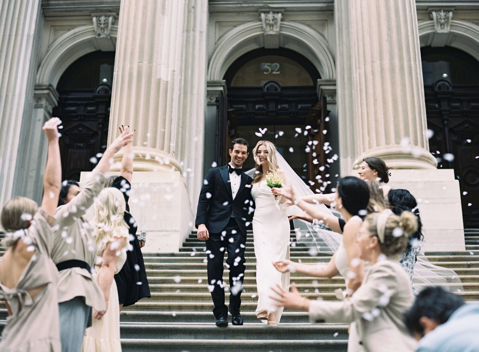 a bride looking back at her groom on a walkway