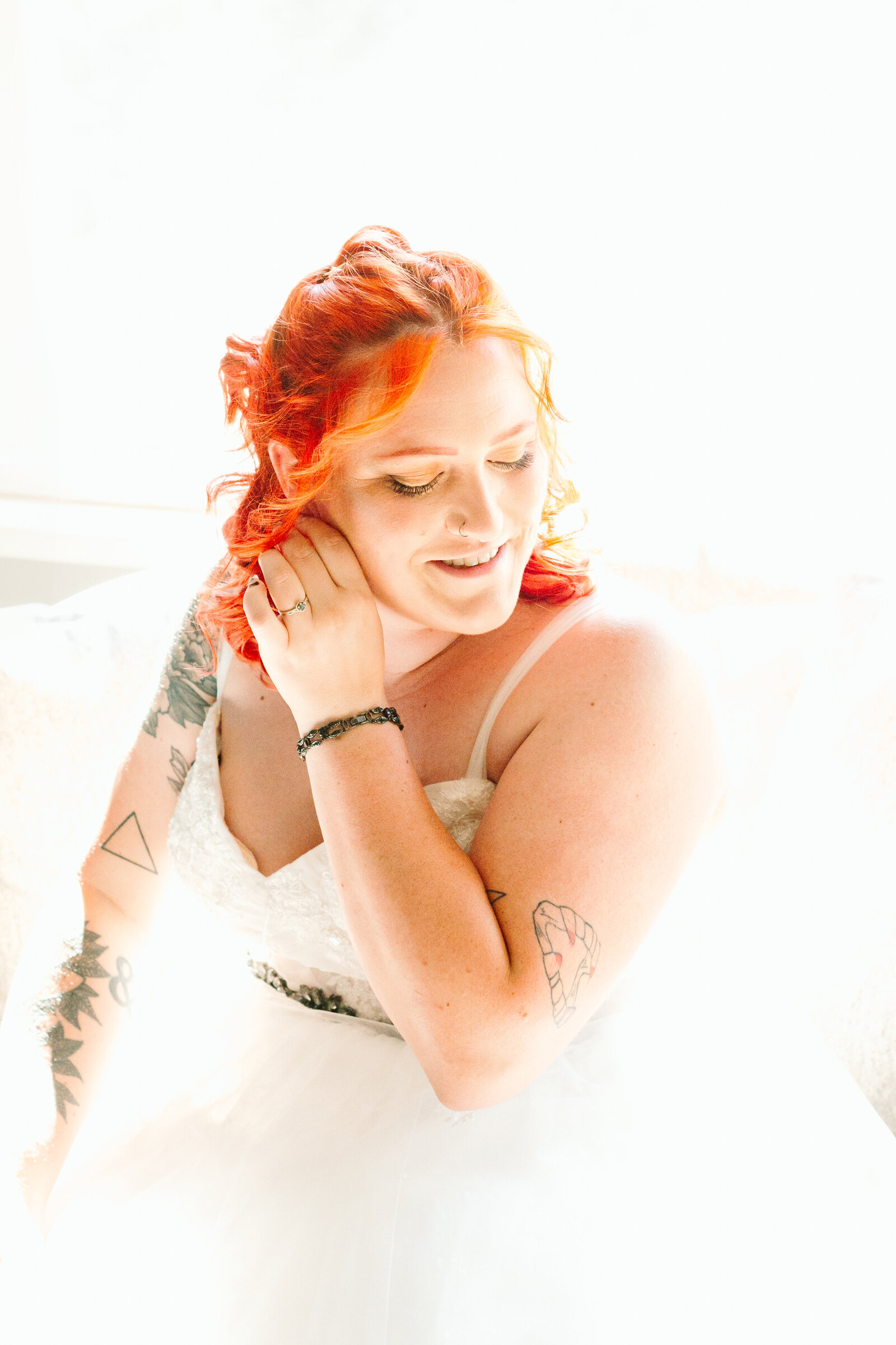 A bride with red hair and tattoos gets ready on her wedding day.