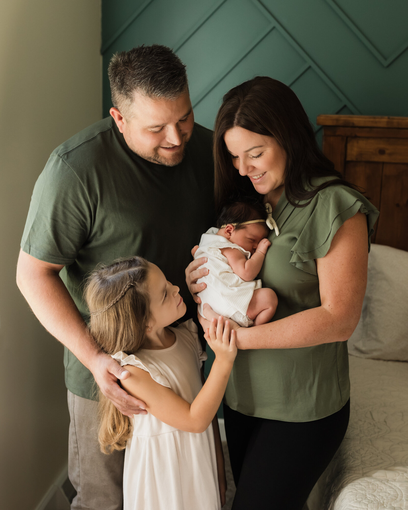 mom, dad and sister holding newborn baby girl for in home lifestyle newborn session cleveland newborn photographer