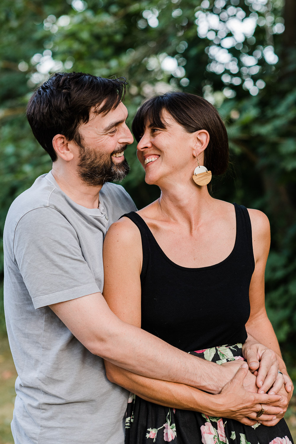 couple snuggle back to front in yard