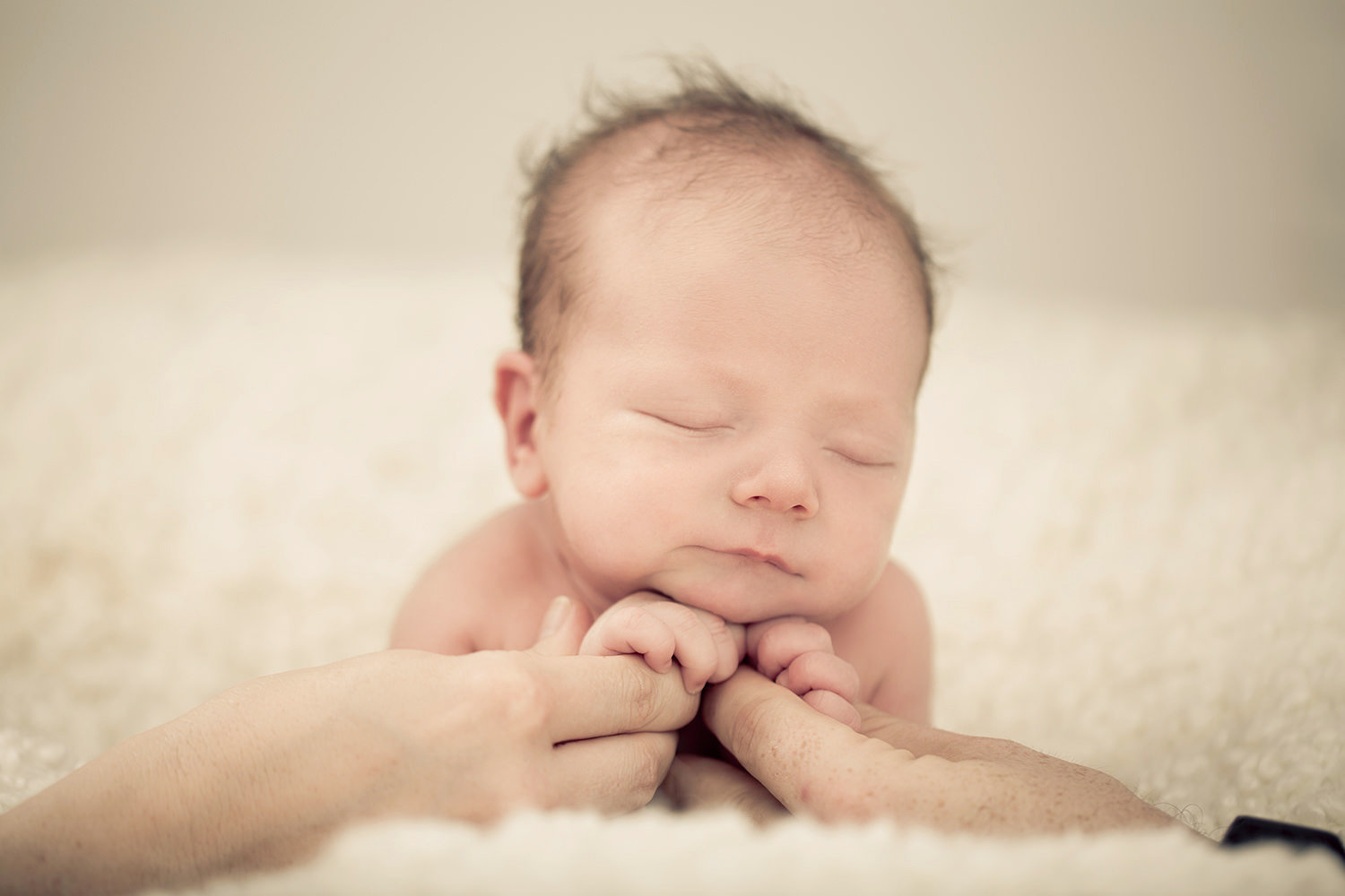 san diego newborn photographer | newborn with parents hand holding him up