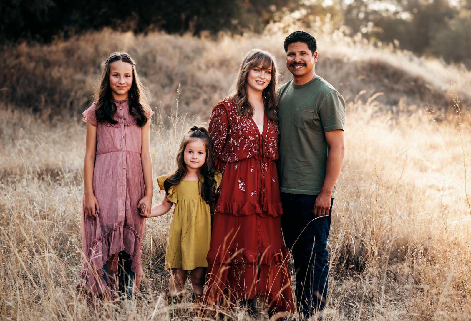 Family of four in a golden fall field on the Monterey coast