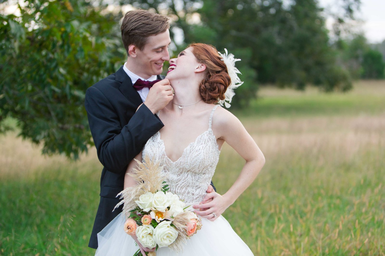 Bride and groom in a field embracing and laughing at Parterre