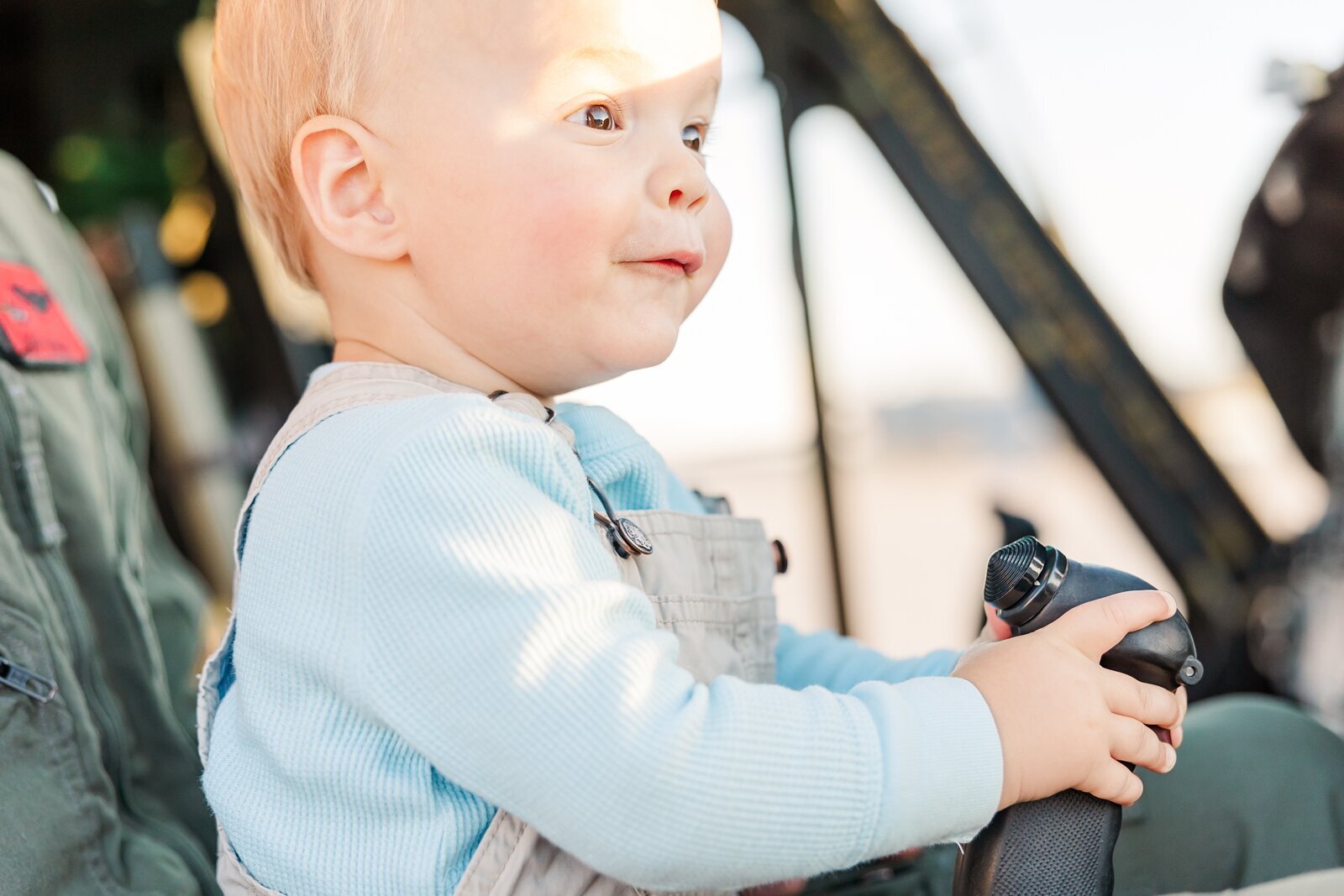 Baby boy holding the controls of a helicopter