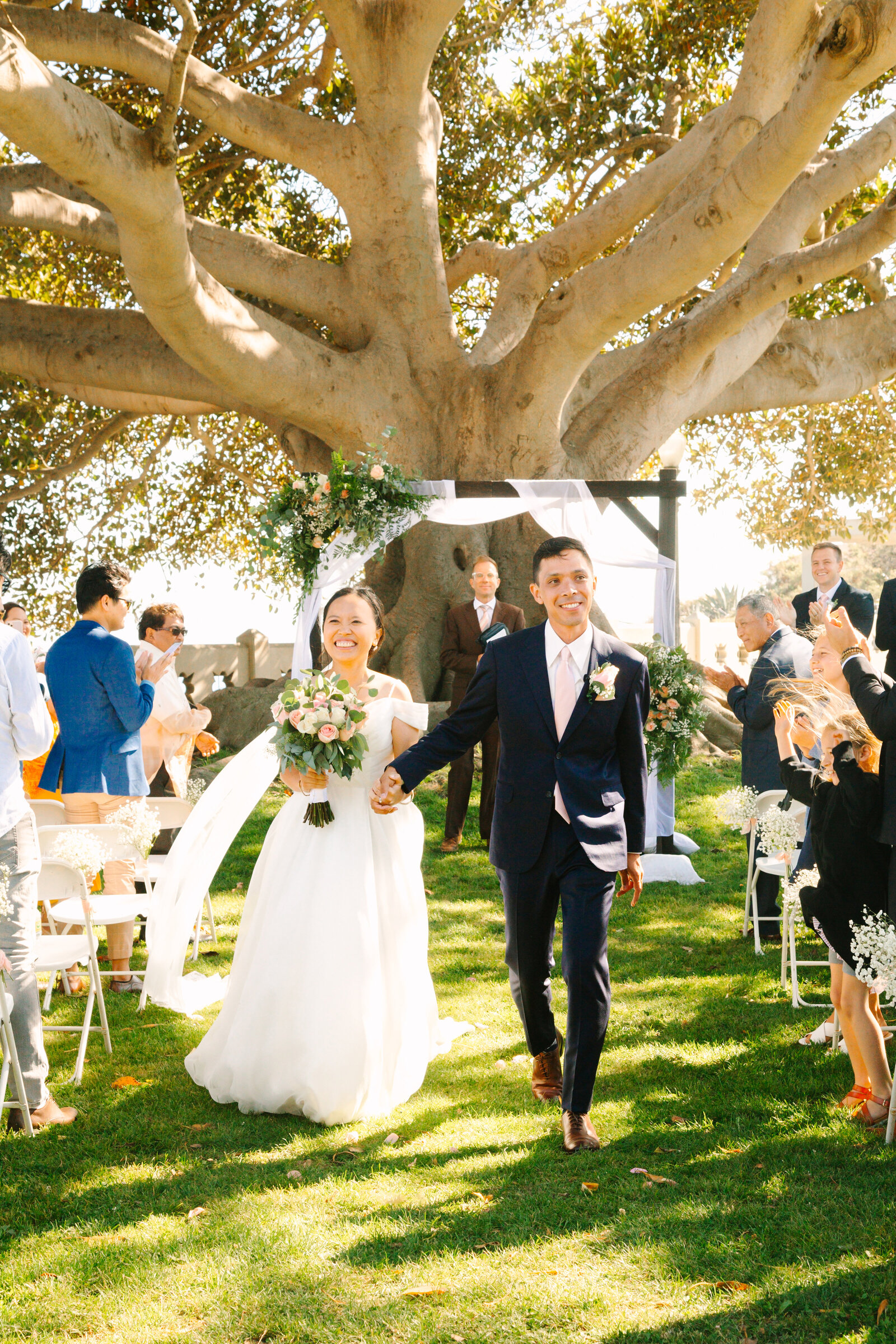 A newlywed couple holds hands after their wedding ceremony in San Pedro, Ca.