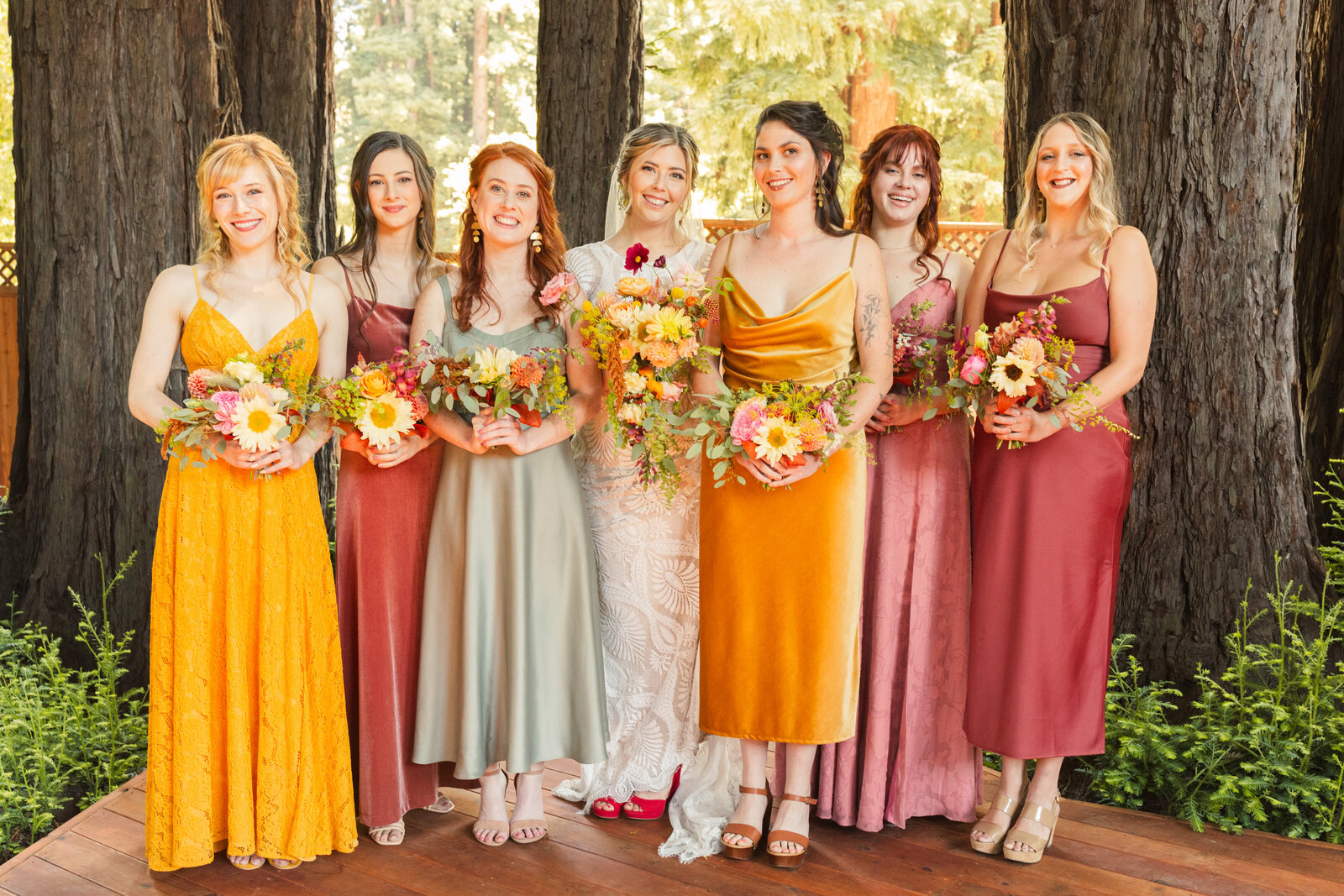 Bride and bridesmaid at her colorful wedding ceremony in Santa Cruz, California in the redwood trees.