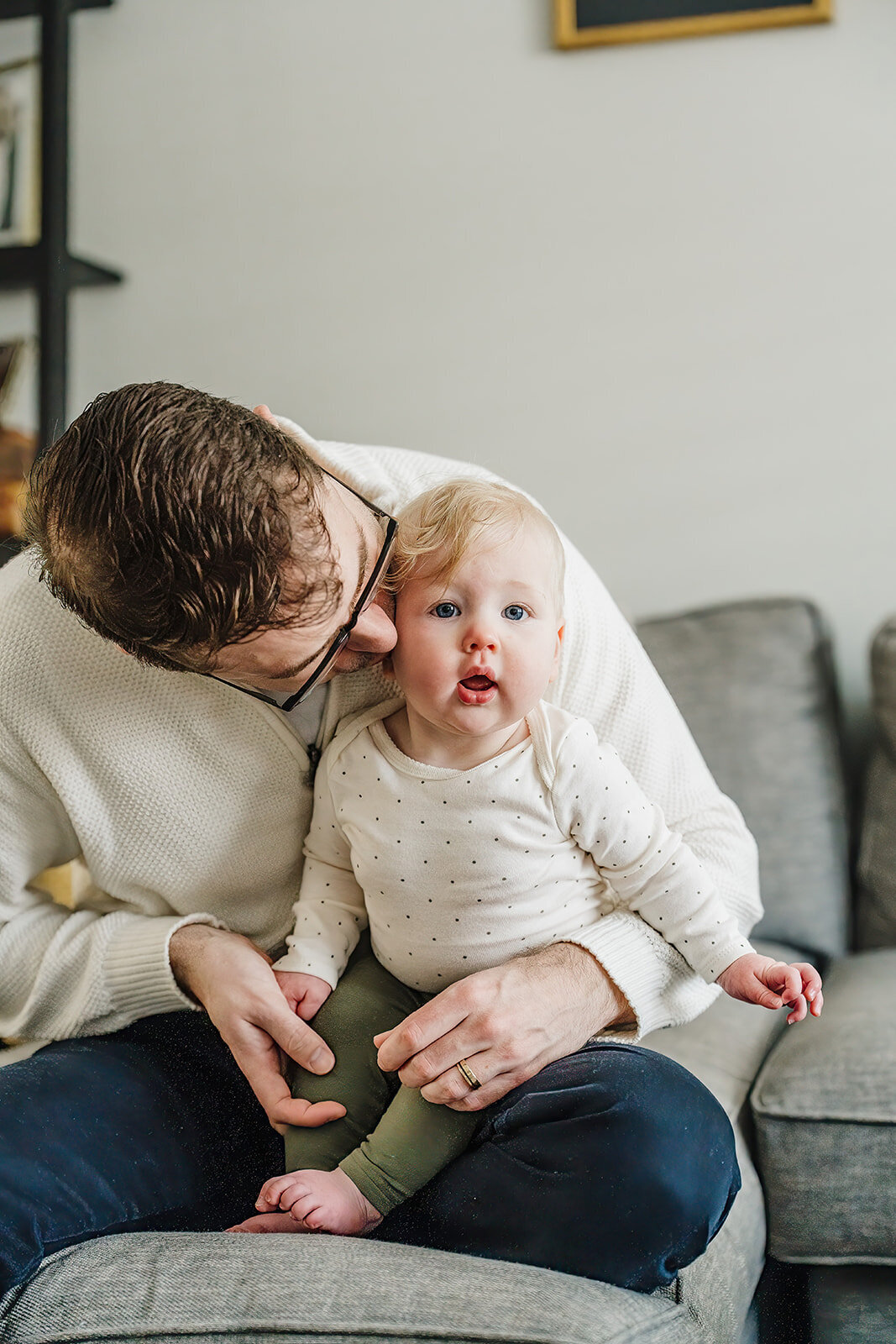 six month old stares into camera from dads lap