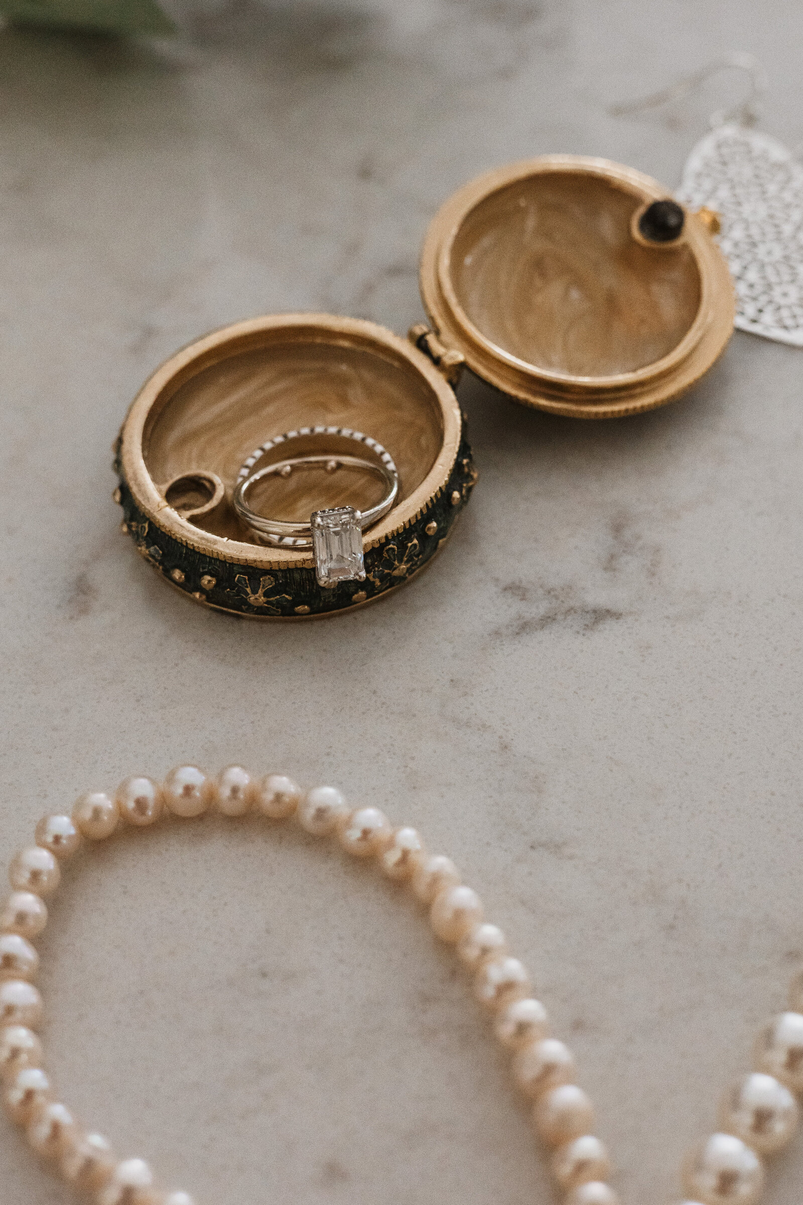 Flay lay of vintage style wedding and engagement ring and holder with pearls | Emma LeeAnn Photography