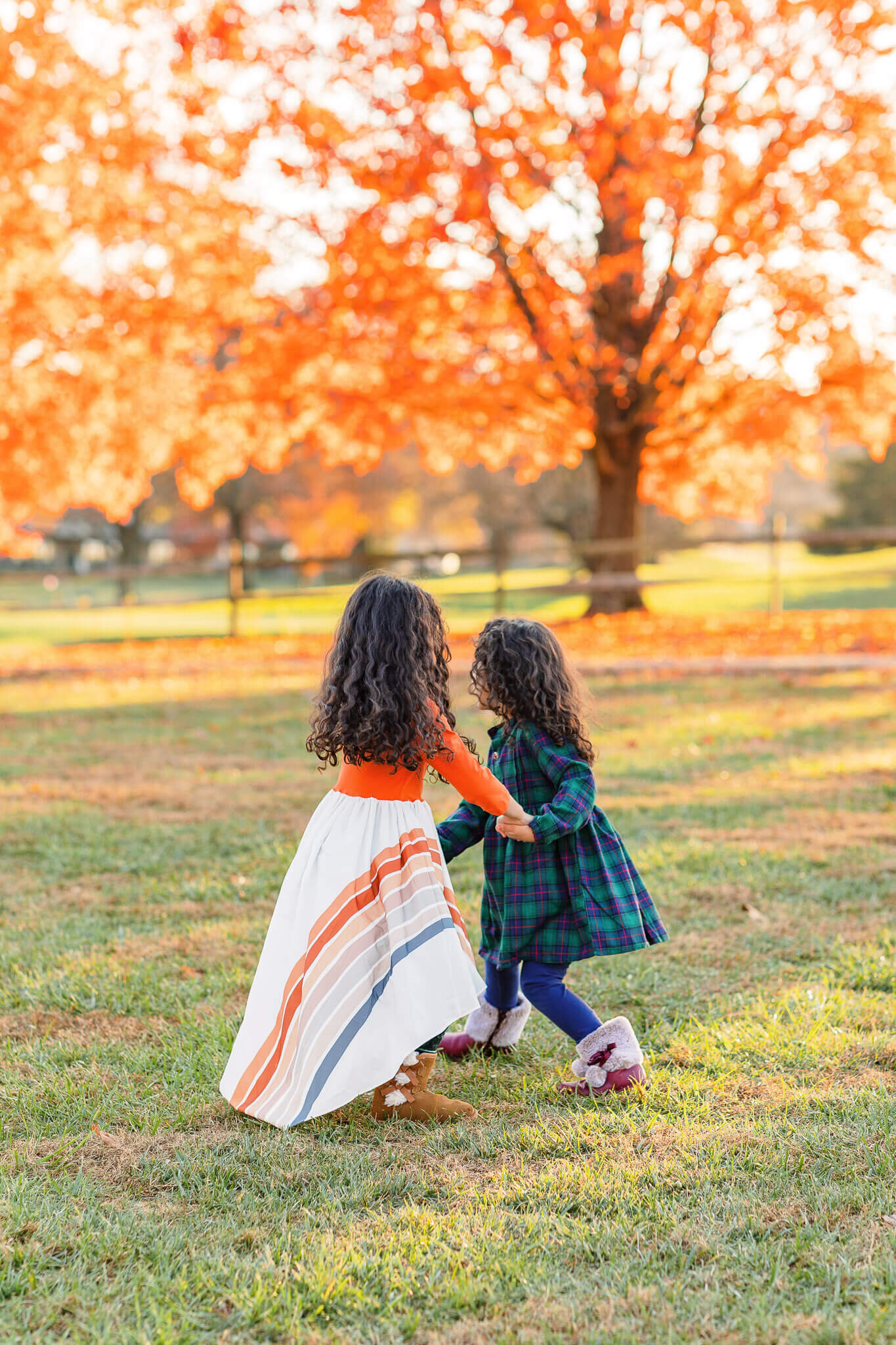 Two little girls dancing together in a field