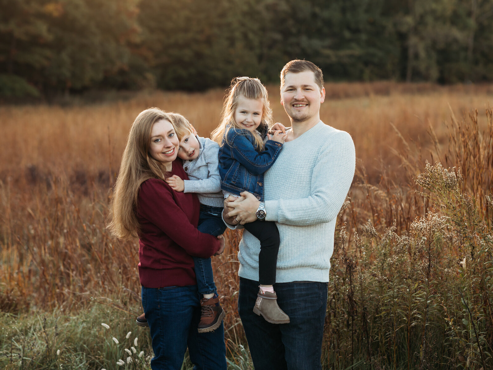 mom and dad holding son and daughter for family photos 