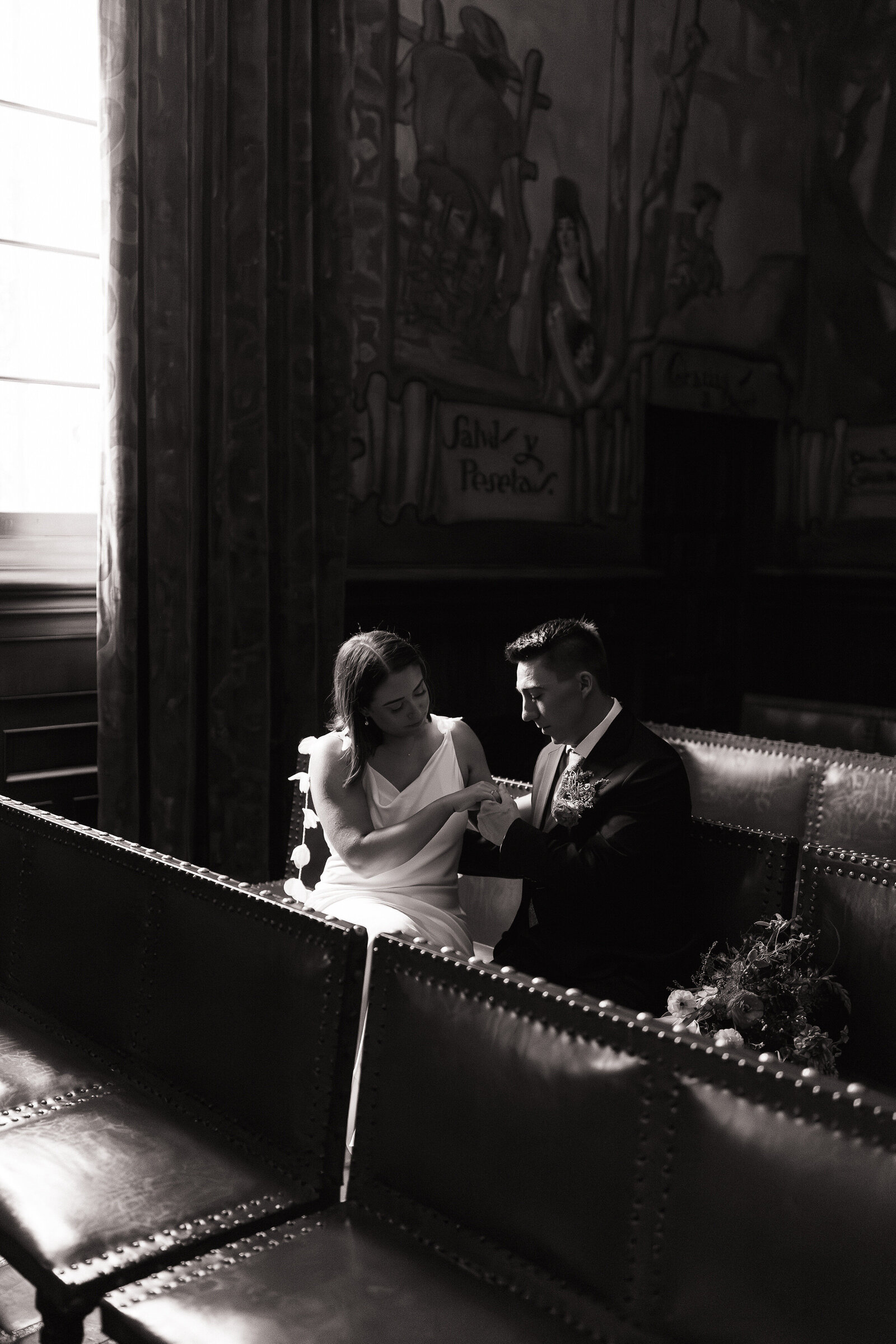 Bride and groom share quiet moment in church pews at Santa Barbara Courthouse wedding