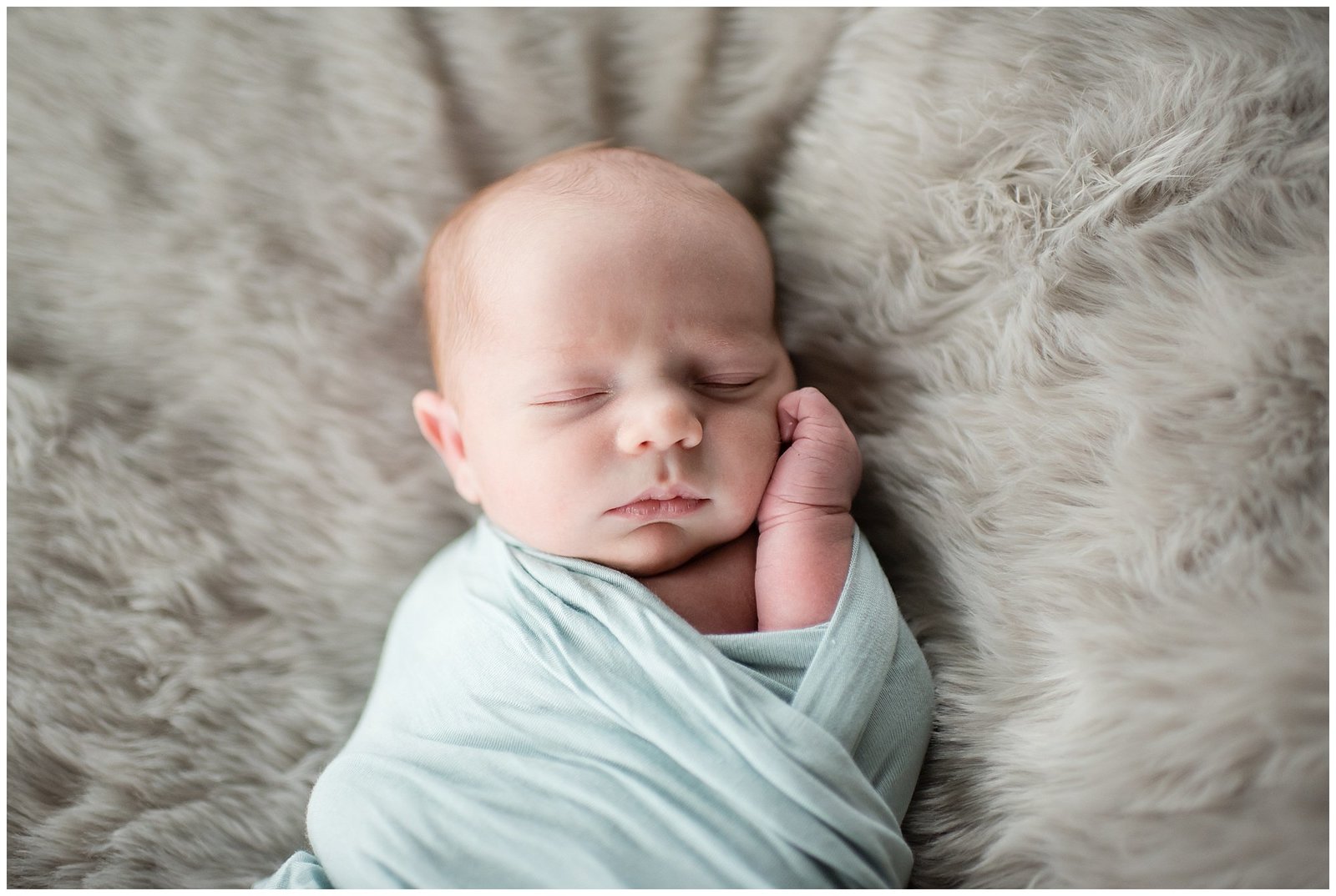 newborn baby boy swaddled with hand on cheek Emily Ann Photography Seattle Photographer