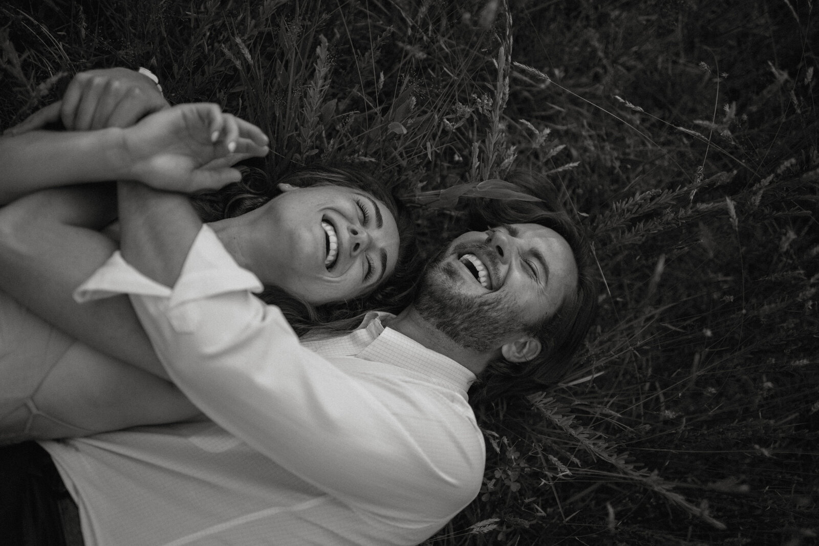 Engagement photos of laying in a field