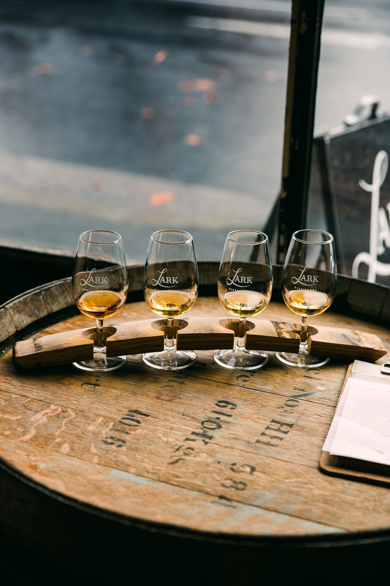 San Diego branding photographer Chelsea Loren for a moody scene Lark Distillery Hobart Tasmania whiskey tasting glasses flight