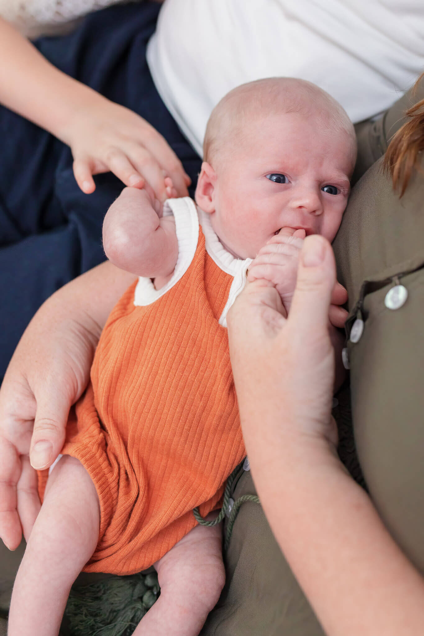 A close-up of a newborn boy in mom's arms.