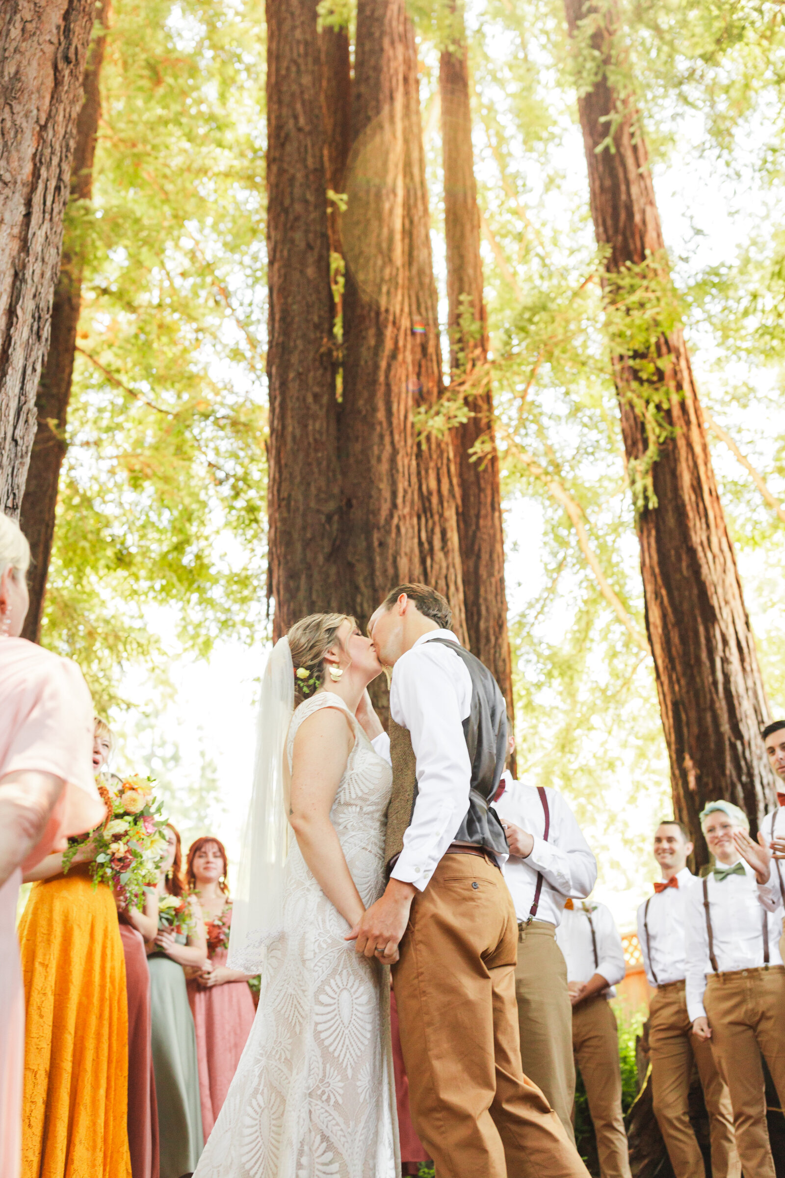 Bride and groom at their colorful wedding ceremony in Santa Cruz, California in the redwood trees.