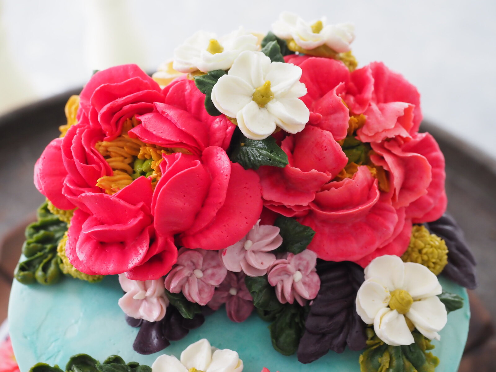 Close up of large buttercream flowers on a cake