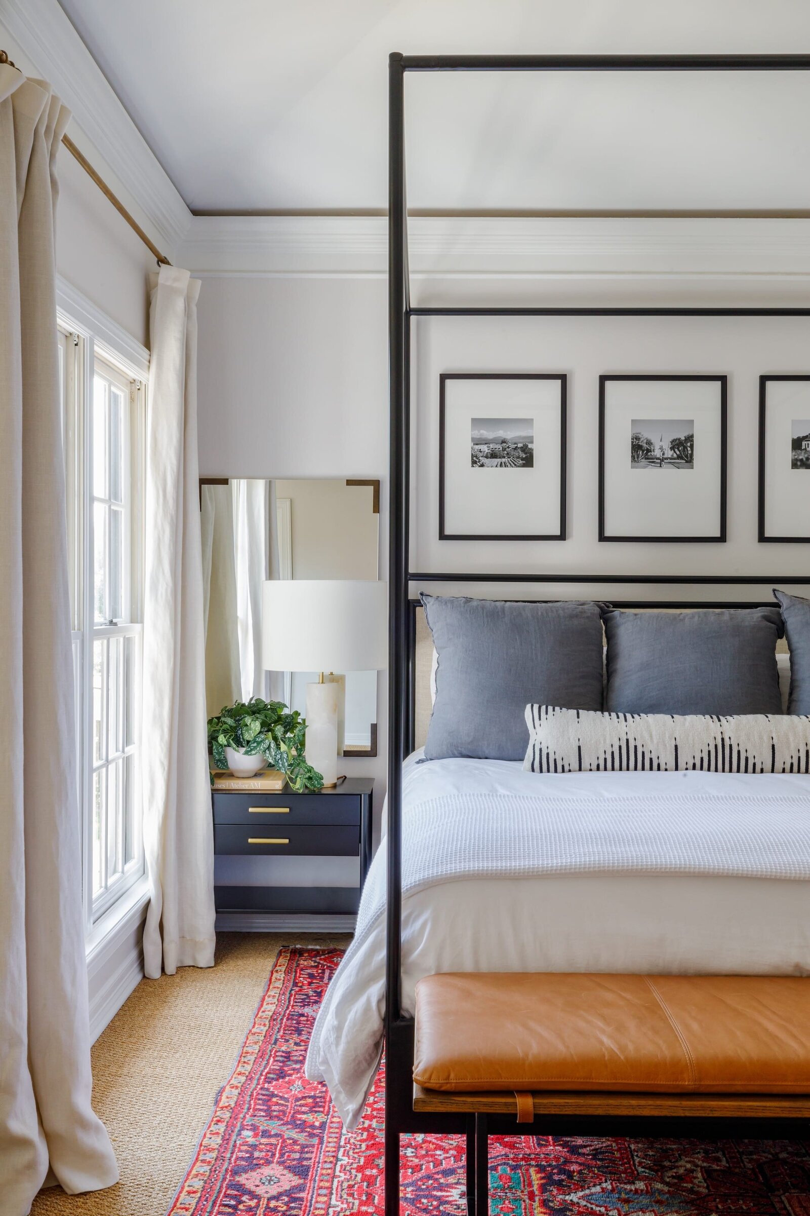 vision and hammer organizing and interior design bedroom with bright red rug and mirror next to bed