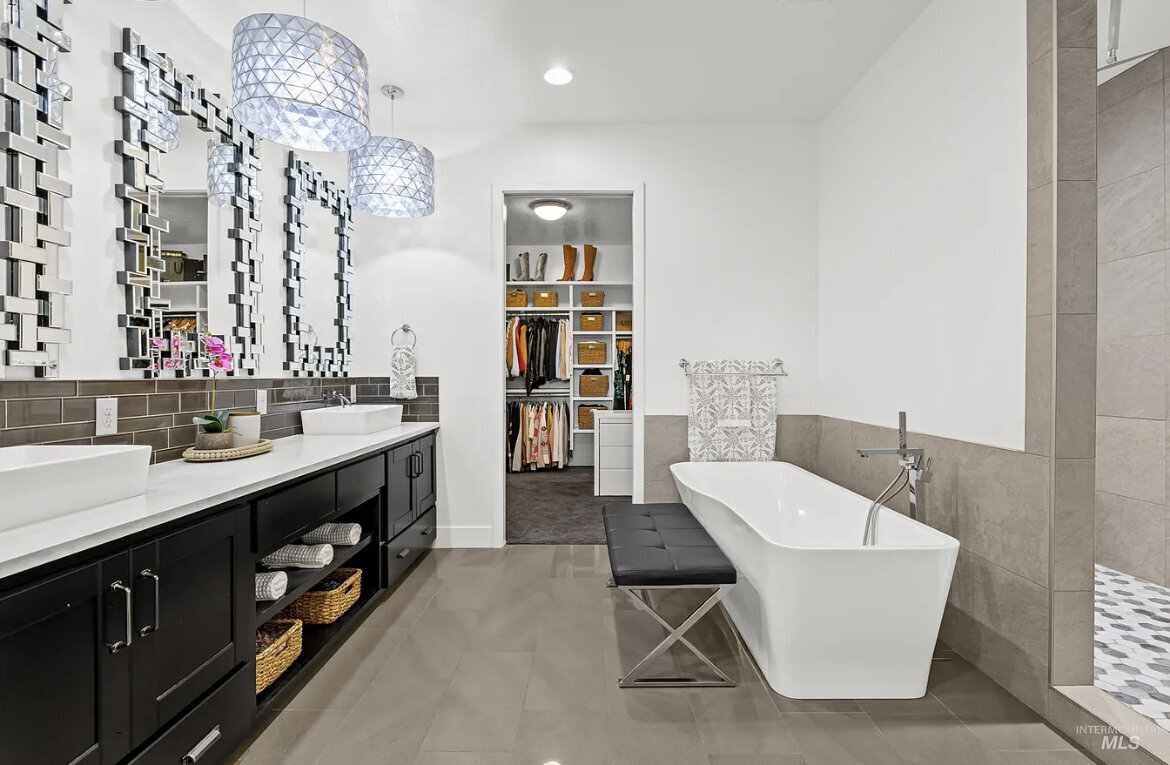 bathroom with black wood his and her vanity with silver trimmed mirrors over sink