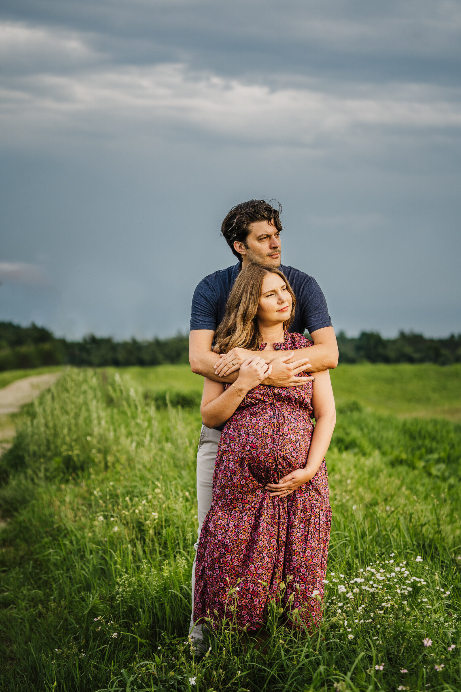 pregnant couple takes photographs under stormy skies