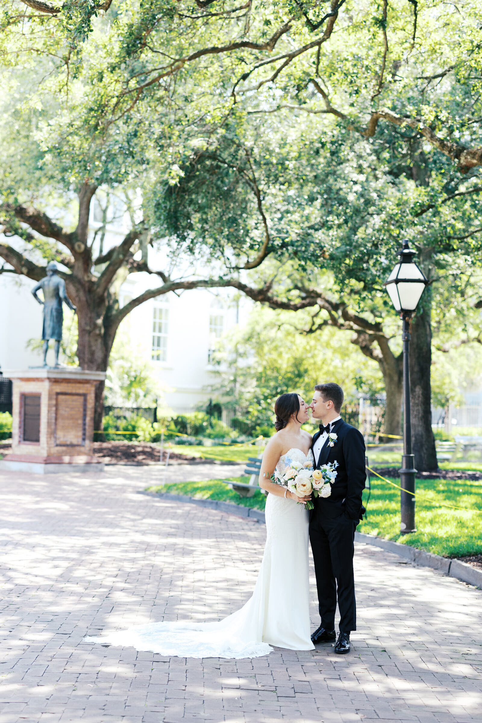 Brunette bride and groom nose to nose in historic downtown charleston, sc