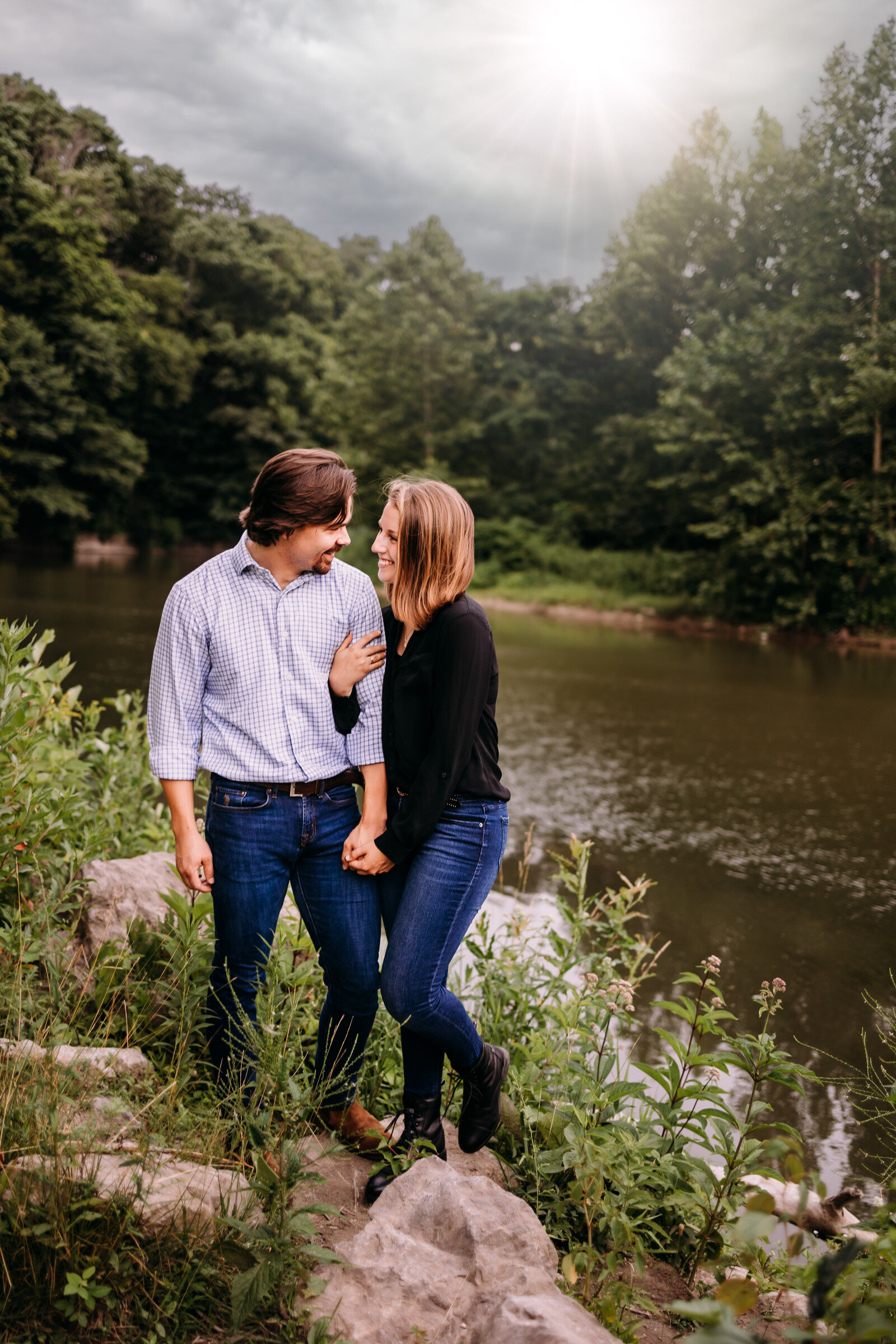 Girl snuggles up to her boyfriend in front of a beautiful creek