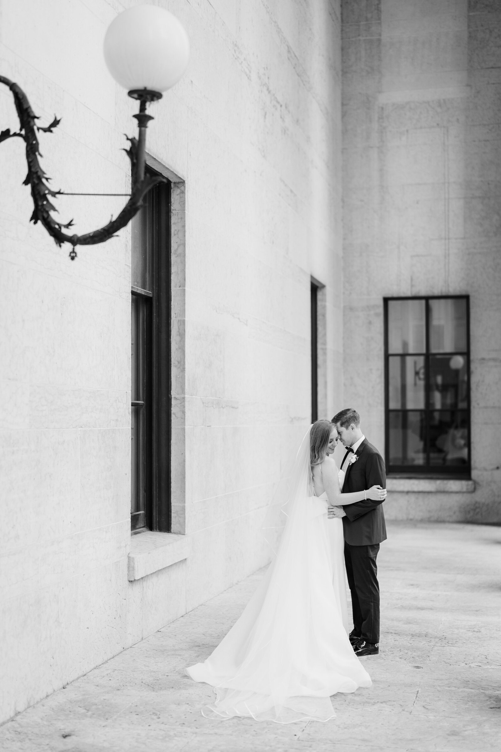 Bride and groom lean in and embrace at the Ohio Statehouse