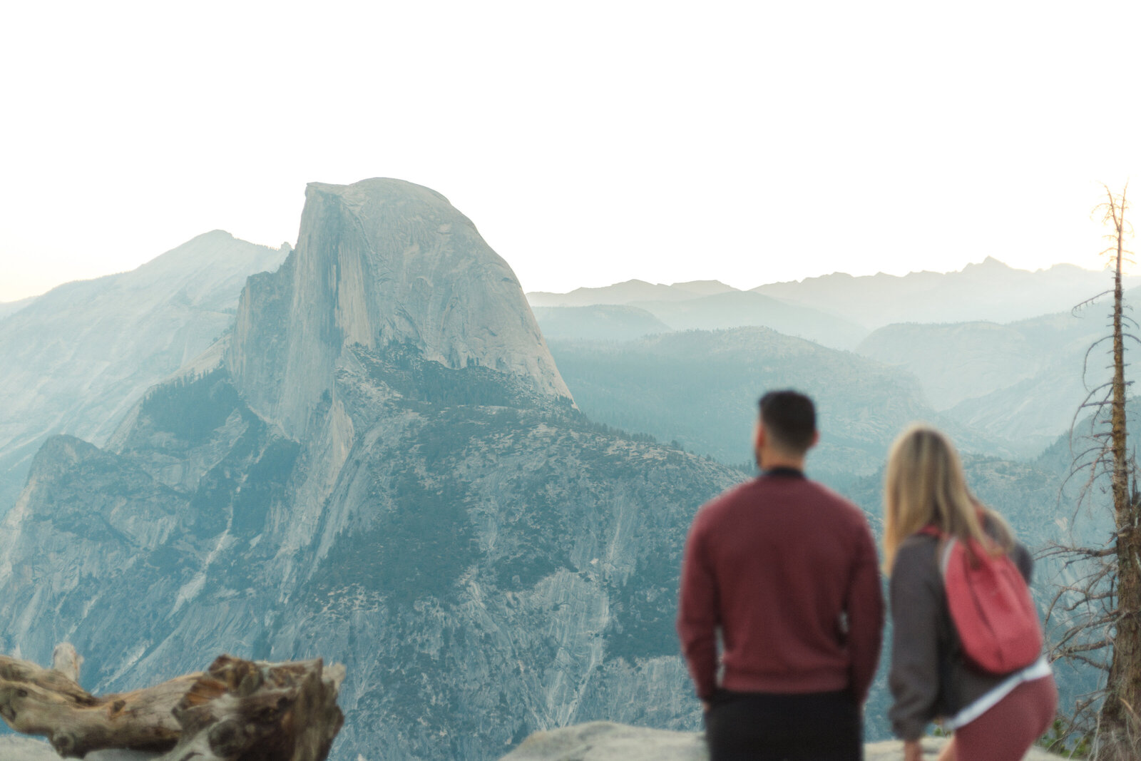 A wedding proposal between two hikers at sunrise in front of Half Dome in Yosemite National Park.