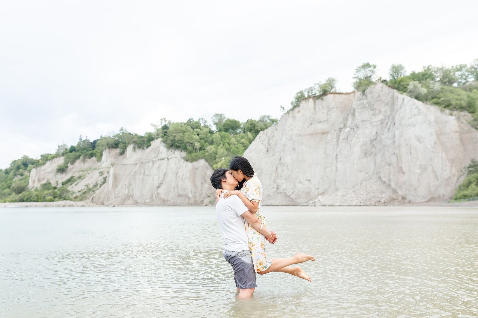 Guy-lifts-his-fiance-up-in-the-water-at-the-beach-during-their-engagement-session-in-hamilton-ontario