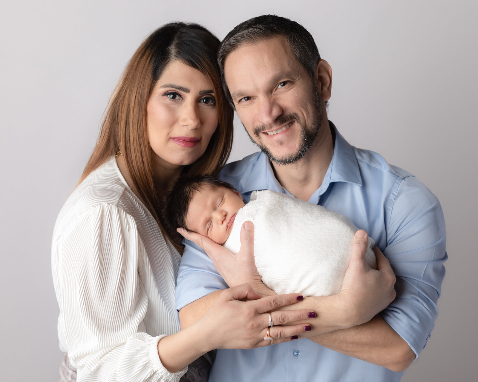 mom and dad holding newborn baby boy for studio portraits
