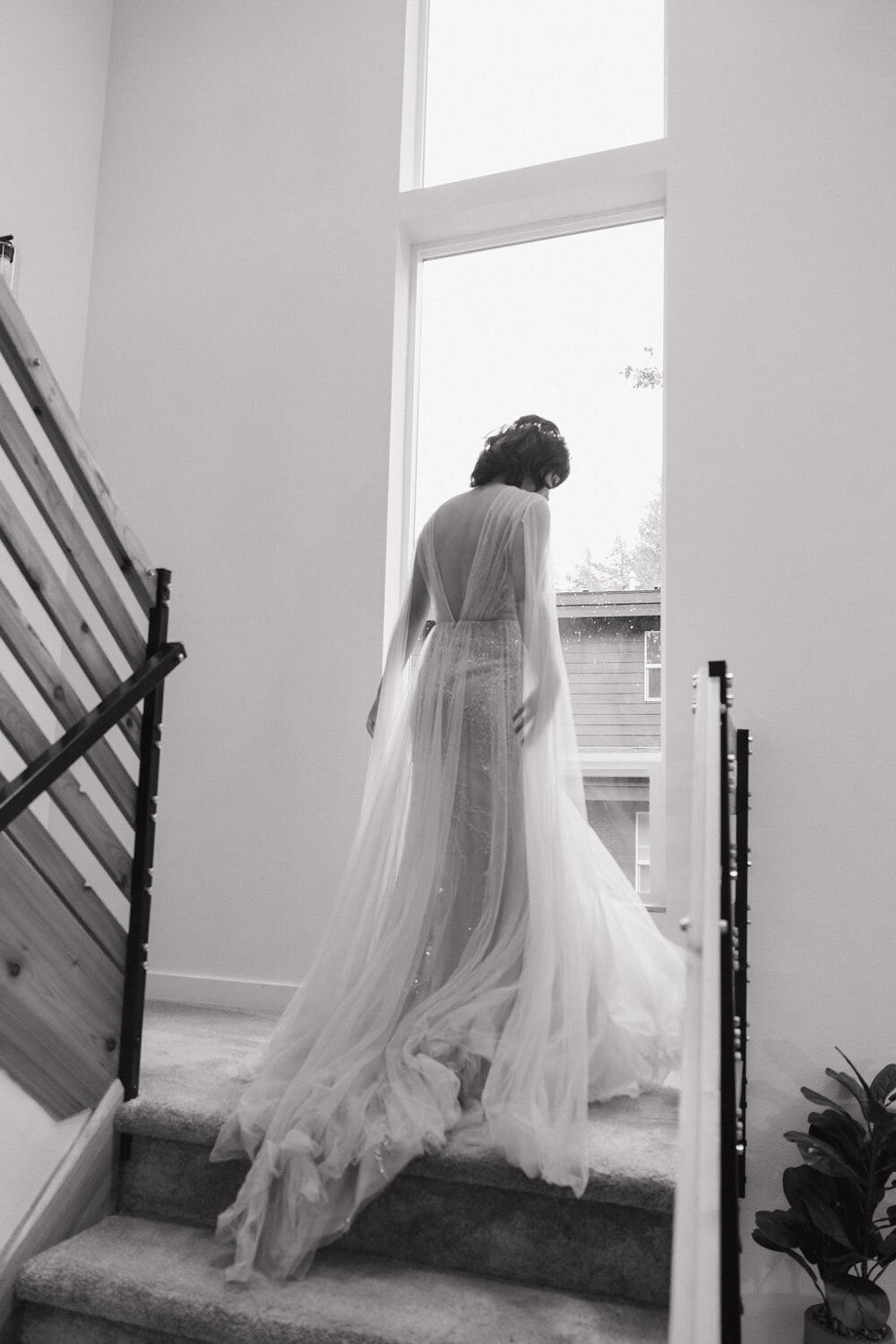 Bride walking up a staircase in a flowing wedding gown