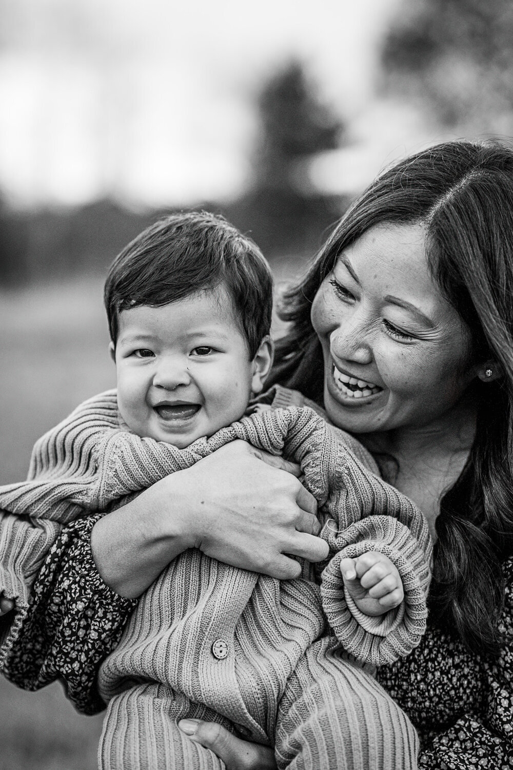 black and white portrait of a mother smiling with baby son