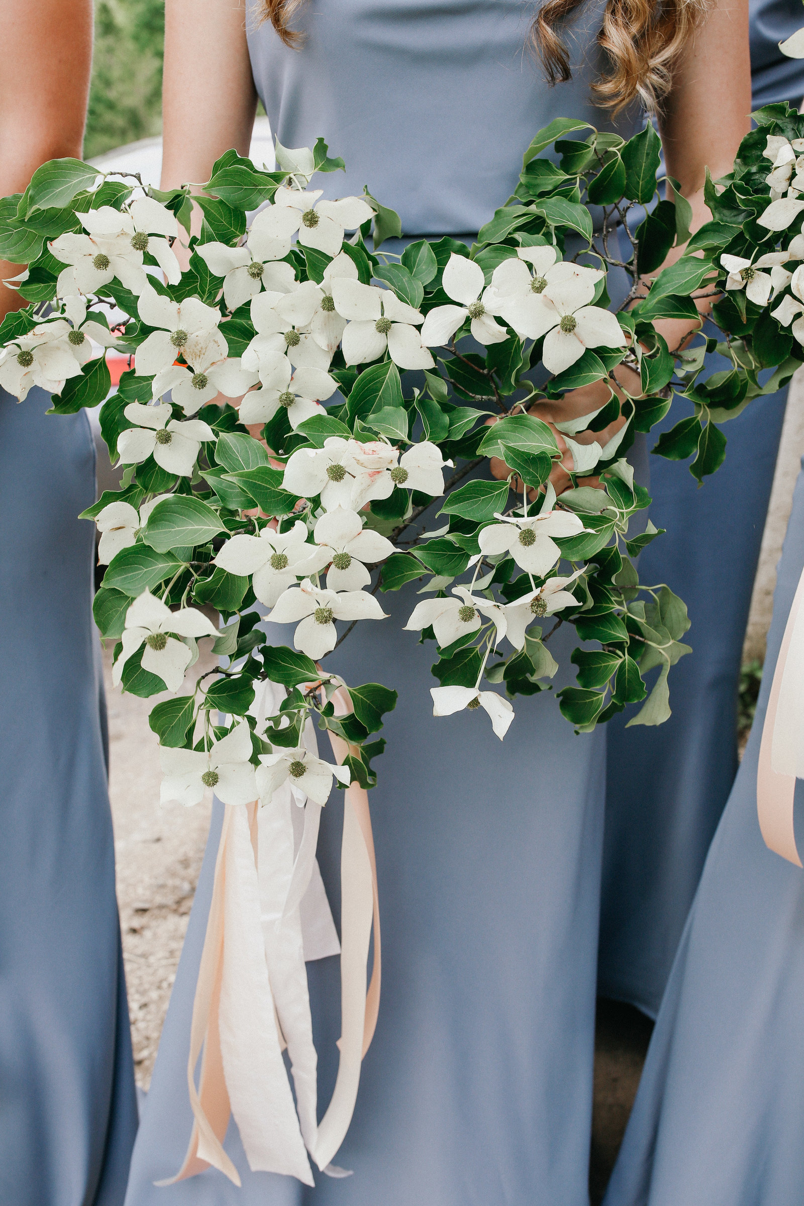 The creamy white dogwood blossoms pop against these gray bridesmaid dresses.