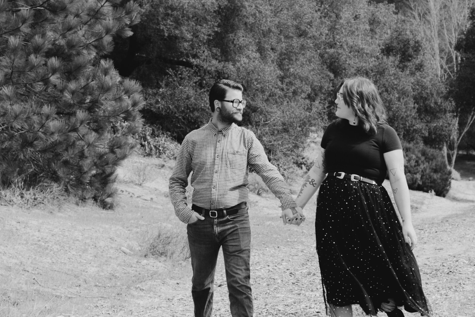 An tattooed engaged couple poses for photos in a redwood forest in Santa Cruz, Ca.
