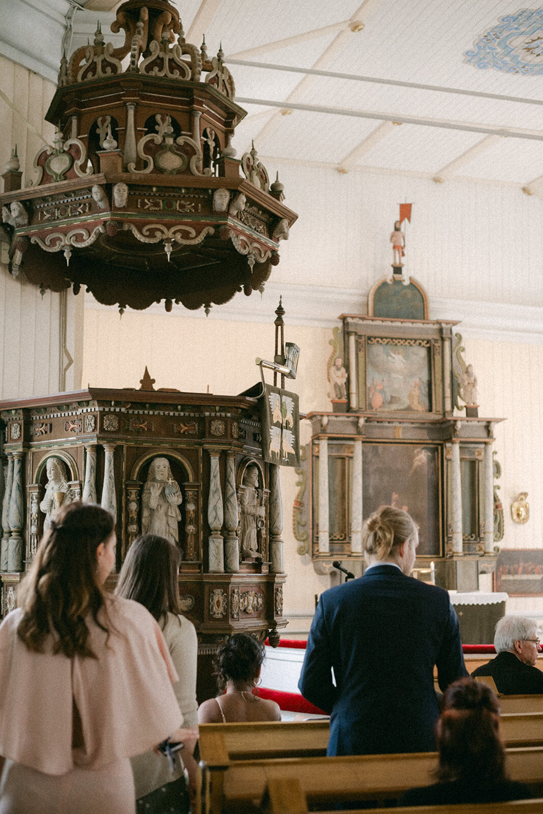 Wedding photograph of guests in Askola church by photographer Hannika Gabrielsson
