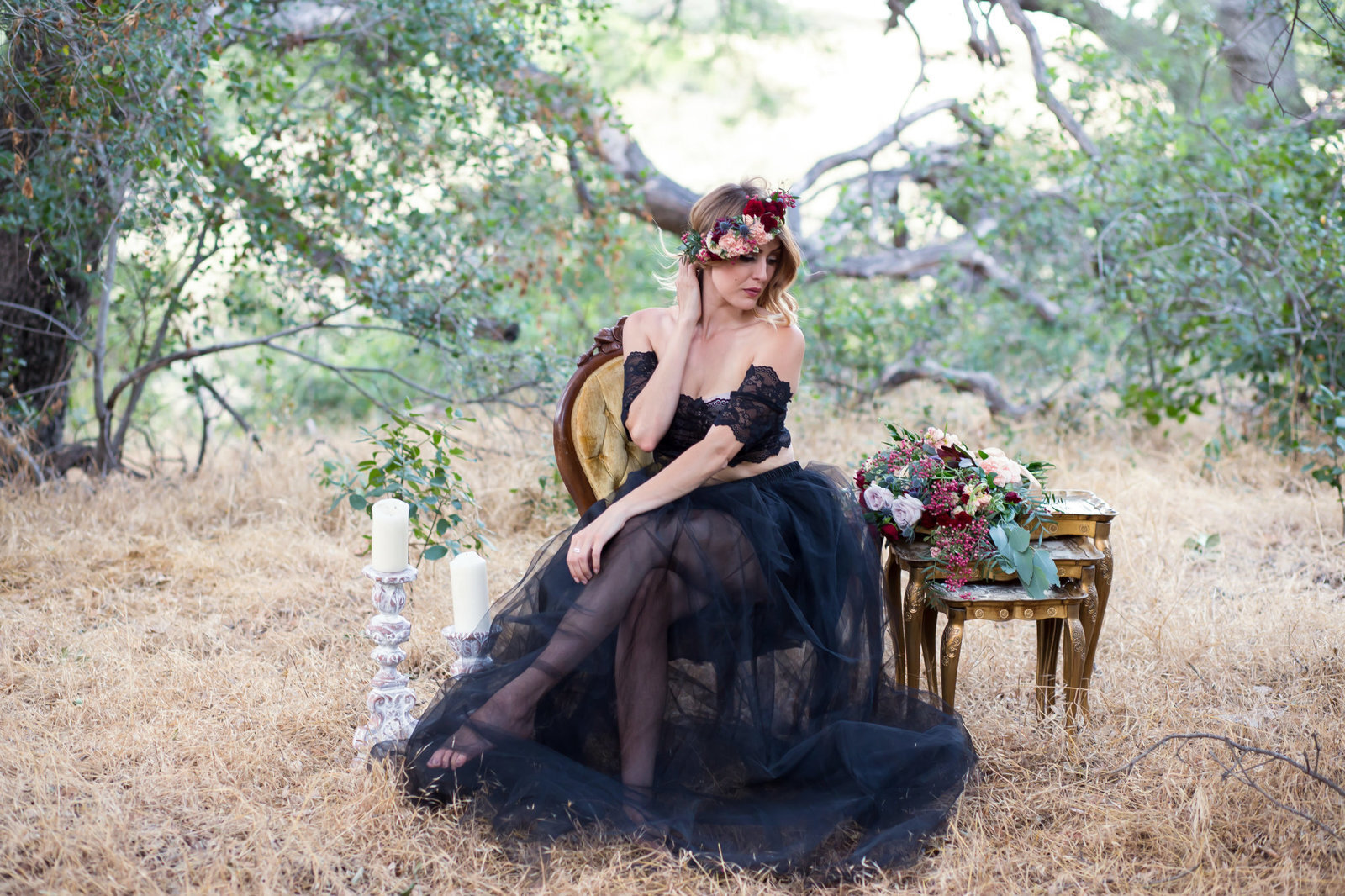 Woman sitting on chair infront of tree in black dress