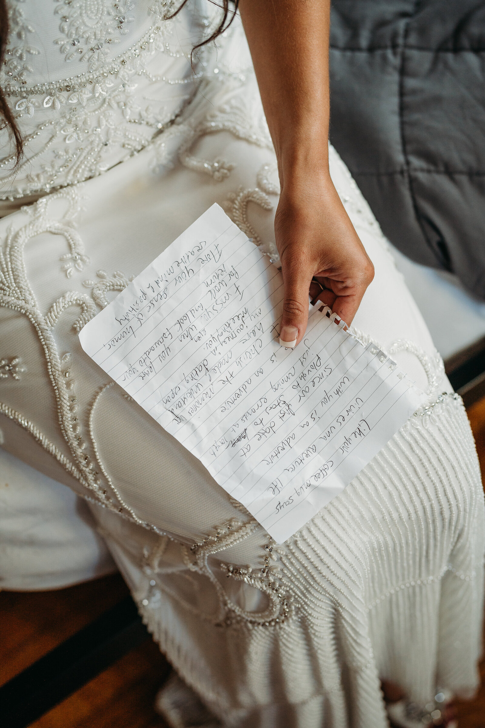 bride holds handwritten vows on notebook paper before wedding ceremony