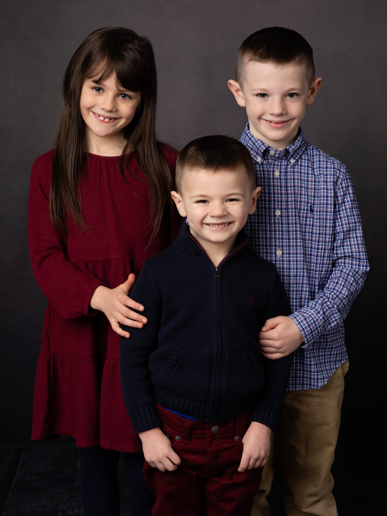 siblings posing for studio portraits
