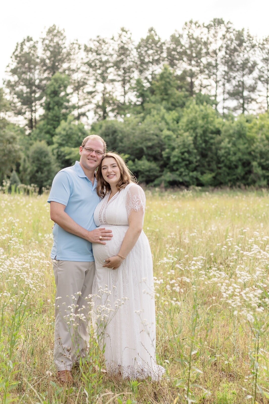 Couple smiling with hands on pregnant belly
